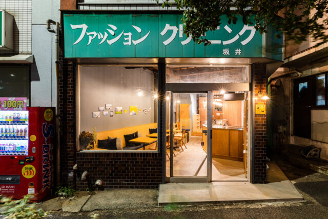 元の雰囲気が色濃く残る外観。大きくクリーニング店と書かれているものの、中はカフェのような雰囲気の不思議な光景。エントランス内外の床は既存タイルにモルタル補修をかけ、内外に連続性を。
