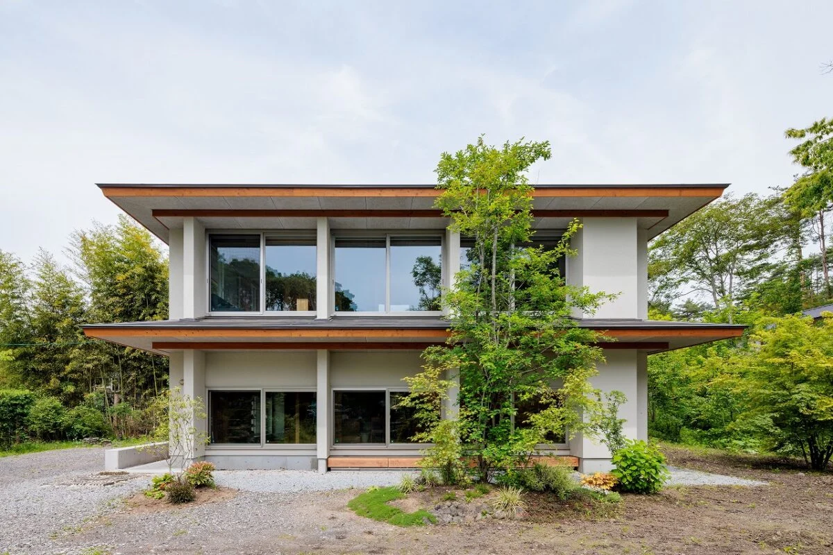 実家側から見た外観。植栽は家を建てる際に取り入れた。１階の窓を地窓のように設けることで外から室内が見えすぎることがない。窓は居間に続く。この窓から庭に出ることも多いのだとか。ご両親とともにバーべキューを楽しむこともあるそう