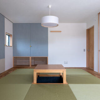 室内にある離れのような和室は、琉球畳と堀炬燵がある現代風。アクセントカラーのブルーの扉で仏壇を目隠し。床下エアコンからの暖気が、部屋の隅にあるガラリを通して室内を柔らかく暖めるという
