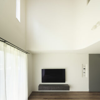 1階リビングエリア。テレビ、テレビボードは壁かけですっきりと。画像右、壁面の一部にアールを取り入れた