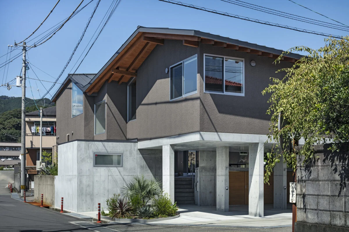 外観（南側）。2つの連続した切妻屋根、ボリュームを分割した家屋、落ち着いた壁色の採用などで、周囲に威圧感を与えず近隣に溶け込んだ存在となっている
