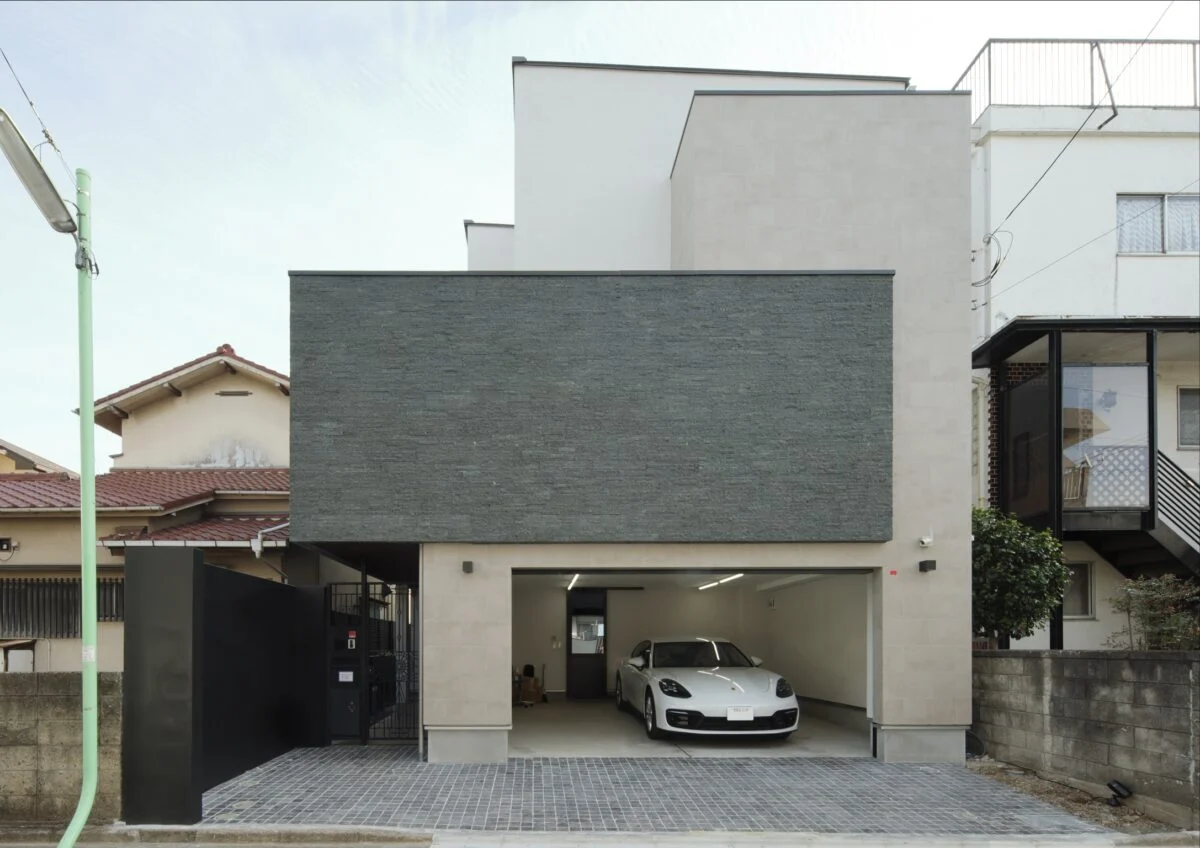 外観。2階のグレーの壁面の内側にはテラスがある。住宅街にあるため明るさを確保しつつ視線を遮った。効率的な動線も魅力。エントランスからだけでなく、ガレージからもご主人の個室やシューズクローク、室内へダイレクトにアクセスできる
