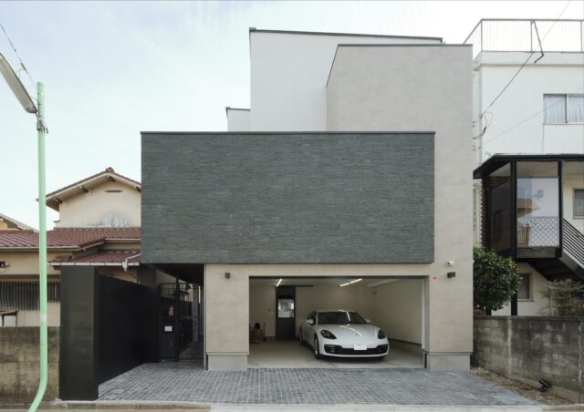 外観。2階のグレーの壁面の内側にはテラスがある。住宅街にあるため明るさを確保しつつ視線を遮った。効率的な動線も魅力。エントランスからだけでなく、ガレージからもご主人の個室やシューズクローク、室内へダイレクトにアクセスできる
