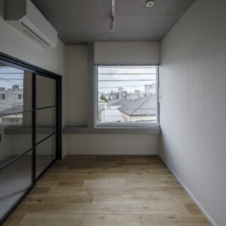 3階の北東角部屋、Ａタイプの寝室。道路に面した東の窓（写真奥）は眺望が抜群。明るい自然光もたっぷり入る。内装は木目とモノトーンでまとめたナチュラルなテイストで、幅広い層に好まれる
