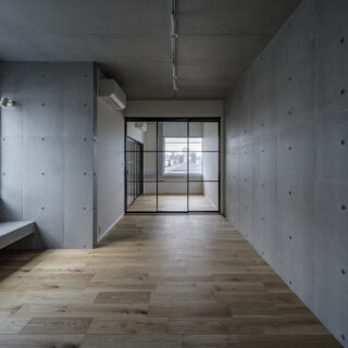 3階の北東角部屋、Ａタイプのリビング・ダイニング。奥の寝室との仕切りは、開放感を損ねないガラスの間仕切り。北側（写真左）に設けた窓の下には造作ベンチ。ここに座って読書をしようか、テレビを置いて映画を見ようか、暮らし方をあれこれ想像したくなる空間だ
