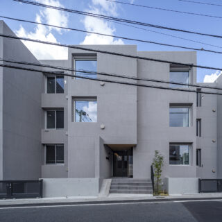 視線がぶつからないよう各住戸を少しずらして配置した結果、立体感が際立つデザインに仕上がった。上品なグレーの外壁は吹付仕上げ。ザラっとした風合いが高級感を生む
