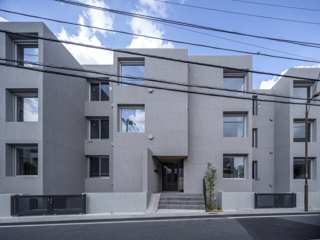 視線がぶつからないよう各住戸を少しずらして配置した結果、立体感が際立つデザインに仕上がった。上品なグレーの外壁は吹付仕上げ。ザラっとした風合いが高級感を生む
