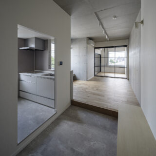 3階Ａタイプ・北東角部屋の住戸。エントランスの大きな土間は、ちょっと腰かけたり、モノを置いたりできるベンチ付き（写真右手前）。こうした造作家具や隣のキッチン（写真左）への動線の良さで、土間の活躍度が格段にアップする