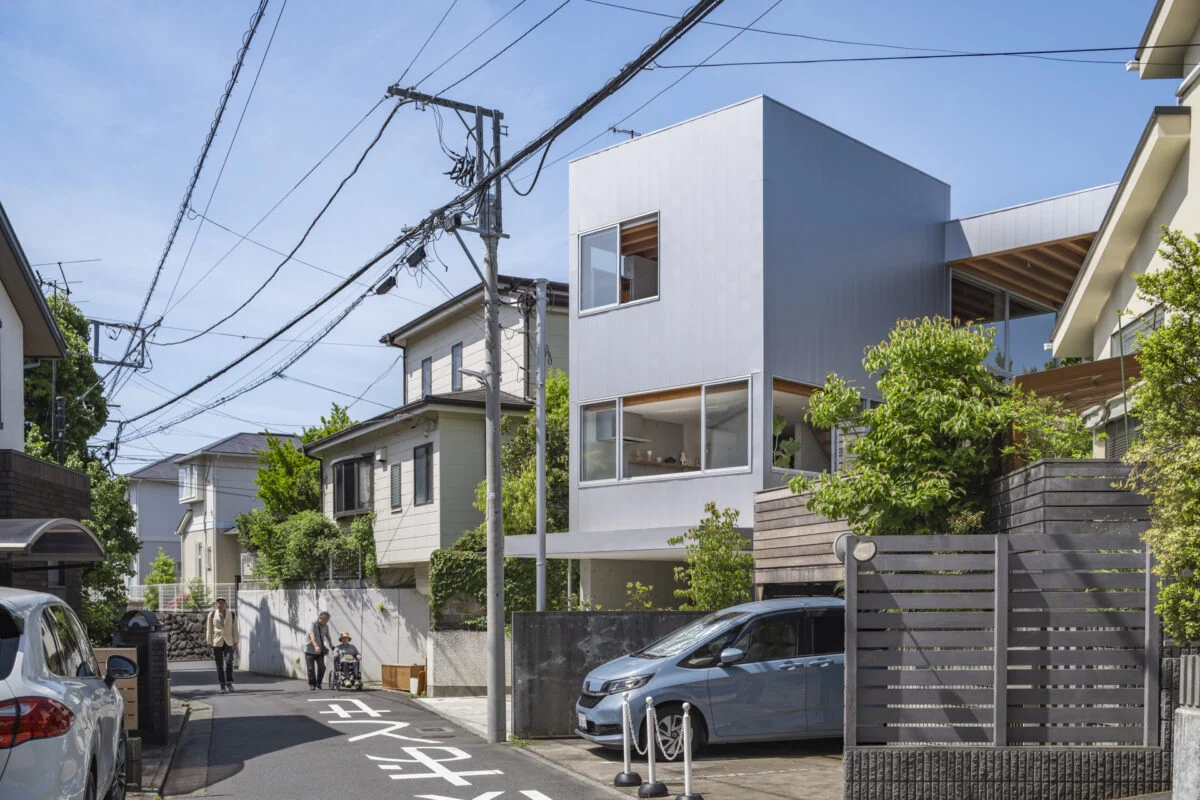外観。街にとけこむ、主張しすぎないデザイン。外壁はガルバリウムで、夕日や隣家の緑を柔らかく反射する落ち着いた色を採用した