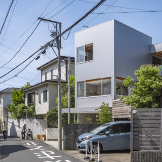 外観。街にとけこむ、主張しすぎないデザイン。外壁はガルバリウムで、夕日や隣家の緑を柔らかく反射する落ち着いた色を採用した