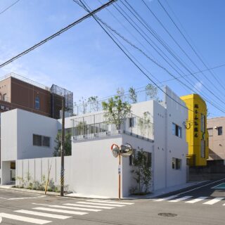 東側と北側が接道した敷地に立つ「LITTLEMATE」。鶴見岳から別府湾に向け傾斜した土地に合わせるように、東面ファサードを低く抑え、奥（西）へ向かって高くなるよう建物をレイアウト。周囲に圧迫感を与えないように配慮した