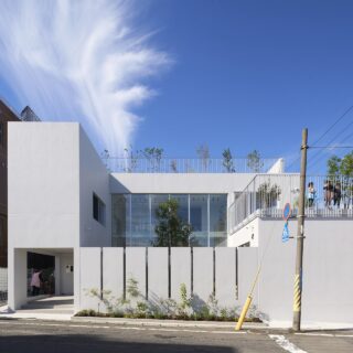建物の周りや中庭、2階テラス、屋上には緑を植えた。地面から屋上まで視覚的に植栽が繋がり、緑に包まれた自然豊かな園舎は、矩形の外観に柔らかさを与える。「通りゆく人や近隣住民へ、緑を借りる”借景”ではなく、緑を提供する”貸景”といった概念を持つ建物になって欲しいと考えました」という