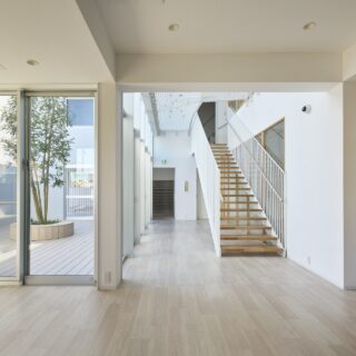 左から中庭、階段室、保育室。手前の空間がランチスペース。建物はコの字型になっていて、写真奥が玄関や園長室、スタッフルーム、書庫などを集めた棟となっている。2階に見える窓がスタッフルームで、ルーム内にいながら園内にも目が届く
