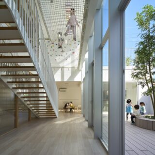 吹き抜けとなった階段室。高さのある空間を活かし、2階の床と同じレベルにエアープレイス（ネット遊具スペース）が設けられている。もちろん、子どもたちに大人気