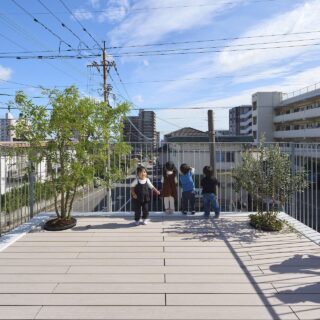 鉢植えの植栽のある2階テラス。フェンスの高さは1300mmを確保、園児が乗り越えることのないよう安全面もしっかり。足元まで見えるので、子どもたちは道行く人たちに手を降ったり、お話したり