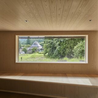 大きな三角形の小上がりがつくられた窓辺の空間。外の景色をきれいに切り取った窓たち。腰壁は積雪を考慮した高さで、雪が積もると窓から地続きに雪景色が広がるように計算されている
