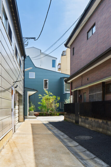 敷地は旗竿地。路地に入ったときに見えるのは一部分だが、屋根のユニークな形やグリーンの外壁が印象に残る
