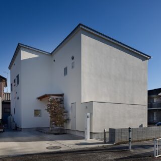 吹き付けの壁にガルバリウム鋼板の屋根をもつ外観。道路に面した西側は、プライバシー確保と西日を避けるため、窓を極力排した。