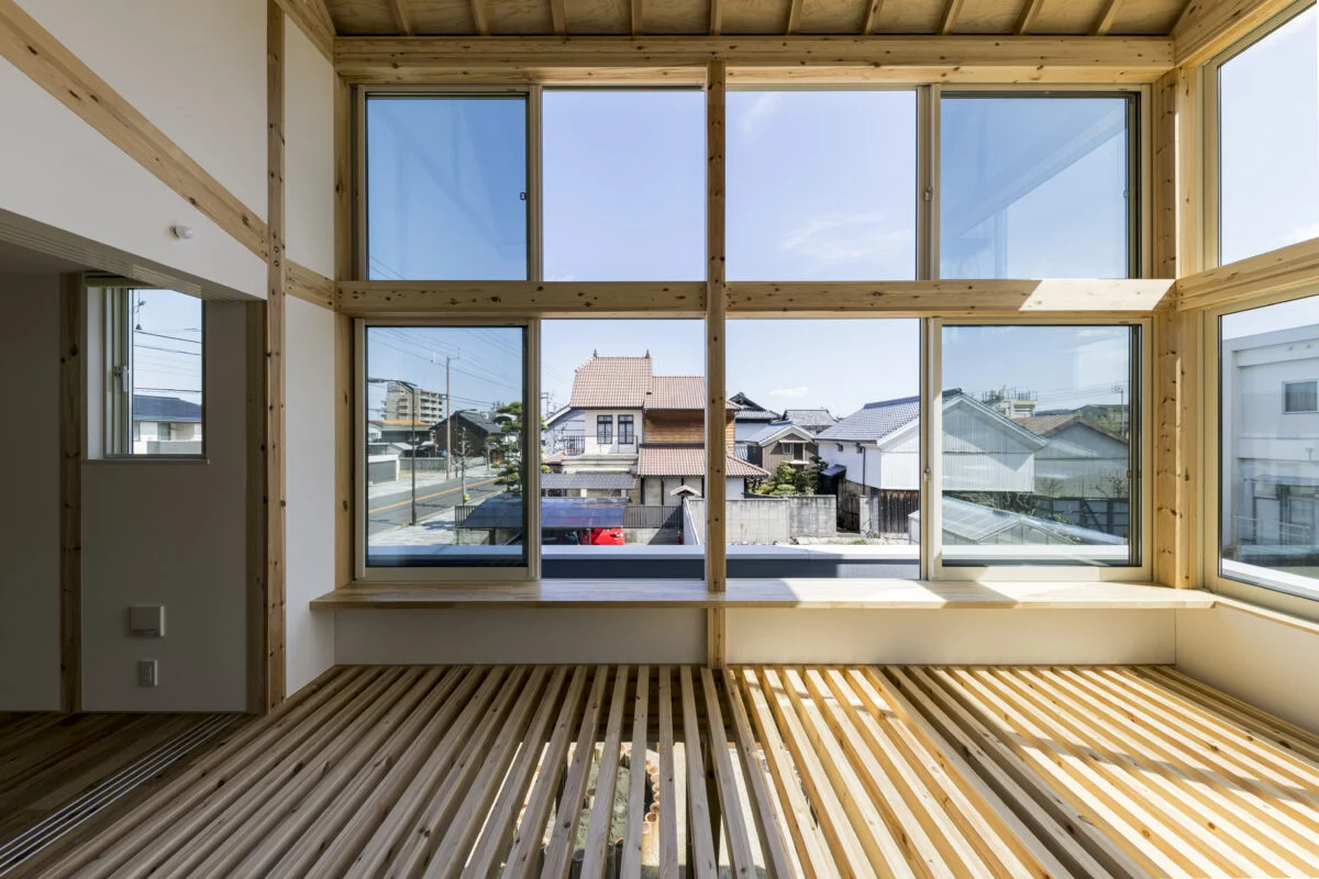 2階書斎。左は子ども部屋(子ども室)。大開口に沿ってカウンターを計画し、格子床を居場所として整えた。ラグを敷いて子ども室の床を拡張させればよい遊び場に。使用する目的に合わせてその都度床面を拡張するイメージだ。住宅街にあるとは思えないほどの視界の広がりが魅力的