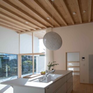 奥様がドラマで見た憧れのキッチンをカタチに。袖壁のおかげで、隣家からの視線は守られるが、光はしっかりと入ってくる。回遊動線で家事ラクも実現。