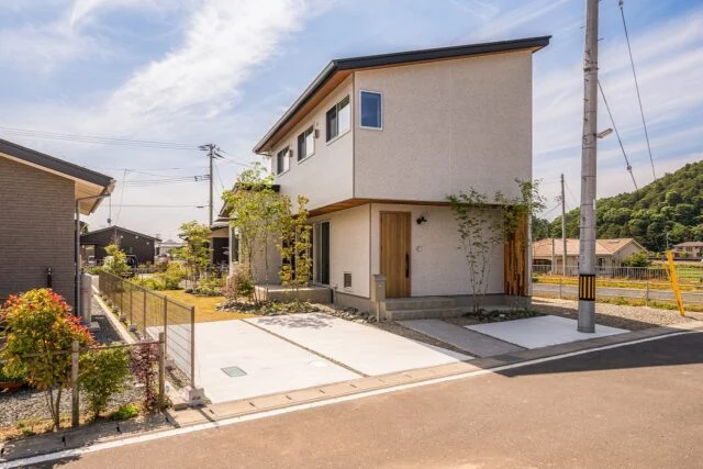 外観。南北の空を遮るものがない、抜けのすばらしさを最大限に活かしたプラン。外観はシンプルに。長年住む家なので、山本さんはあまり多くの色を使わないことが多いという。土地の向きは真南を向いていなかったが、建物を真南に向けてパッシブデザインを実現した