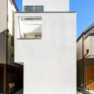 白い箱を２つ重ねたようなシンプルで洗練された外観。道路に面した部分には窓を設けず、玄関も奥まった部分に設けるなどプライバシーに配慮した。バルコニーの開口と３階の窓の大きさを統一するといった、細かな部分にまで保坂さんの美学が貫かれている。