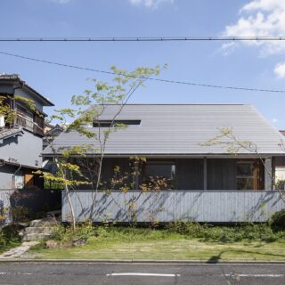 正面外観。左側のエントランス部分にある階段を見ると高低差があることがわかるが、全体的に高さを感じない。宙に浮いたテラスと、その下部に配された低木や草花の効果だ。外構をセットで設計するメリットがよくわかる