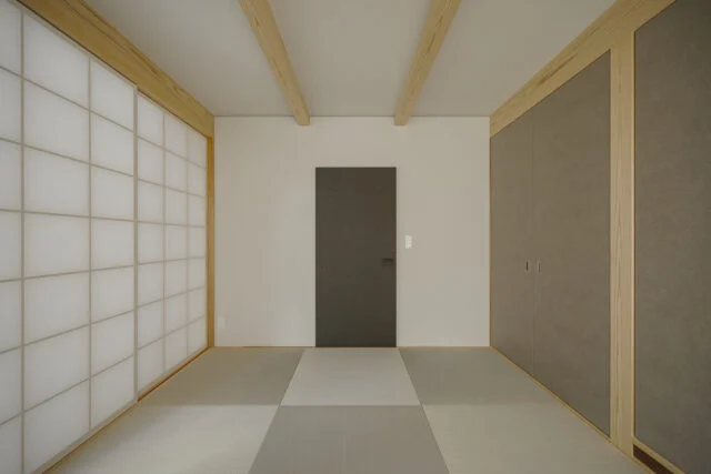 母住居1階和室。廊下からの出入口となる正面の引き戸は鴨居を省き、すっきりした印象に。右に設けた押し入れは、壁面をフラットにするため引き戸ではなく開き戸とした