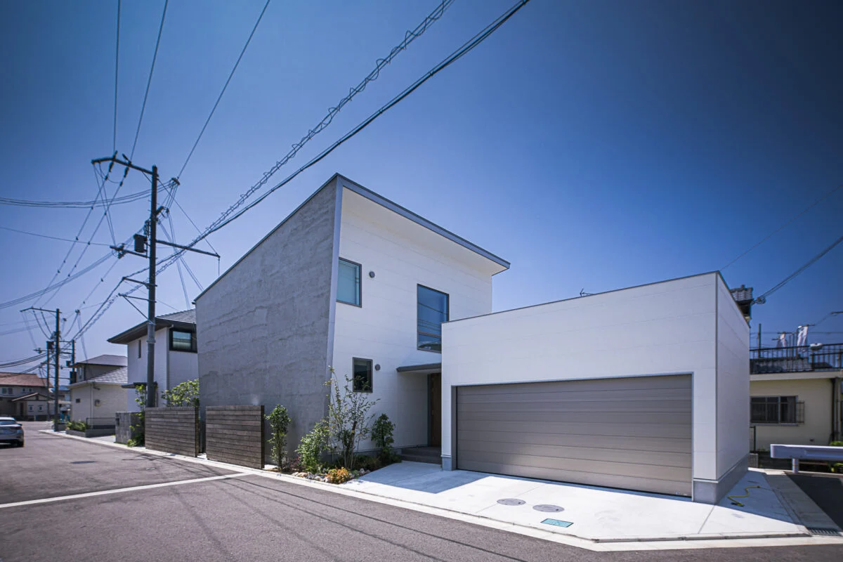 北東から見た外観。住居部分は、道路からの視線が届きにくい北面の高い位置に窓を開口。東の壁面と屋根が大きく張り出しているおかげで、正面からは気配すら感じられない。右の大きな窓は階段のもの。豊かに光を取り込み、家中に届ける