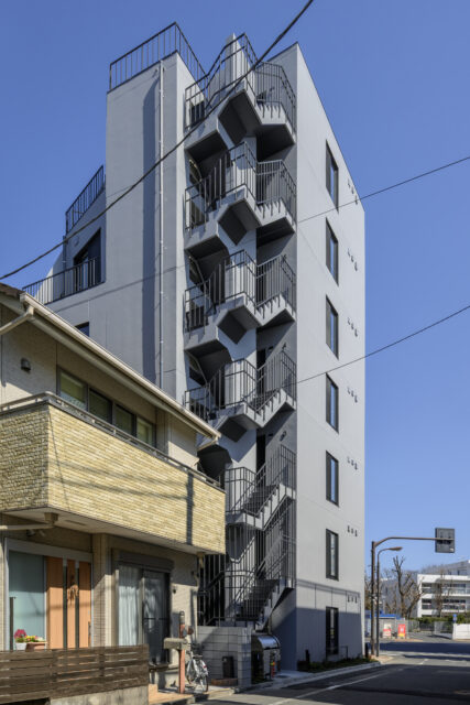 裏手にあたる南西側の屋外非常階段の踊り場に、法規的な主要な出入口（玄関）がある。