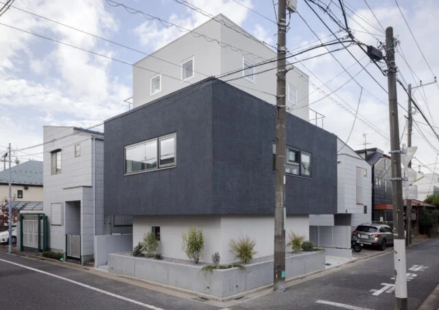 世田谷の閑静な住宅地の角地に建つM邸。白とグレーの３つの箱が積み重なる洗練されたフォルム。3面に等しく窓を配置しバランスも整えた。