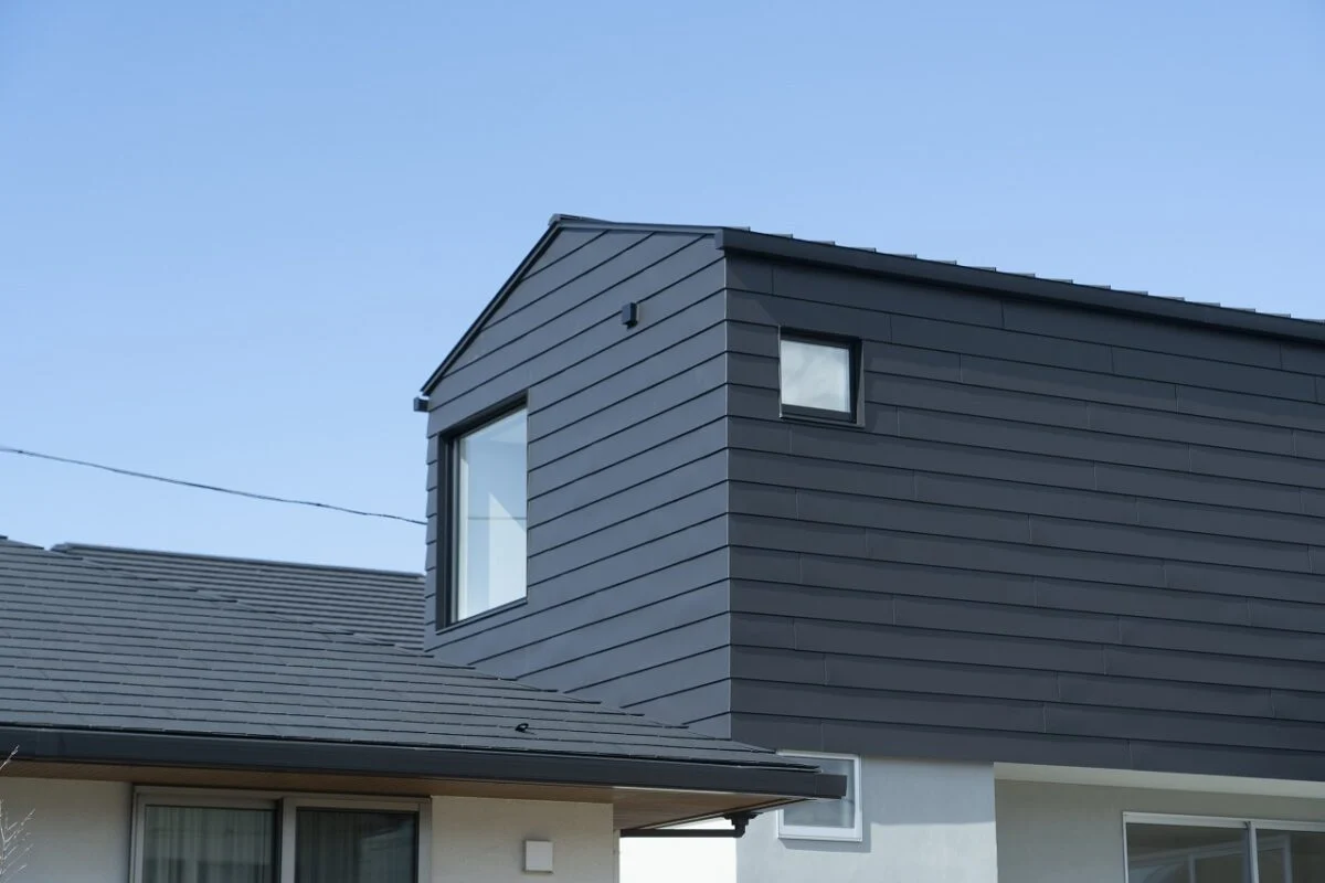 南西から見た外観。大きな窓は寝室のもの。1階は左官仕上げの壁らしく、光や影の表情から手仕事の趣が感じられる