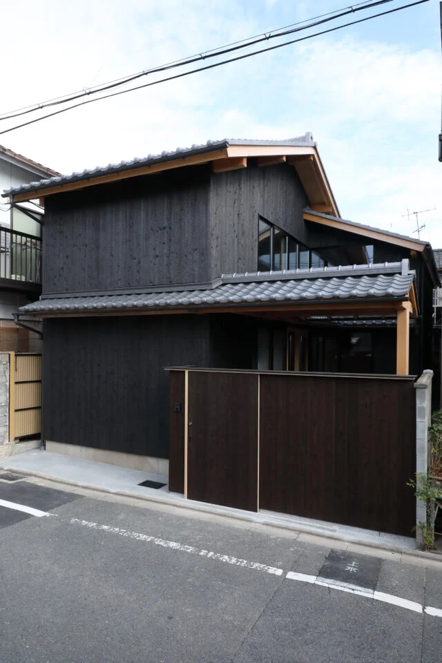 現代に蘇った、京町家。杉板の外壁、瓦、敷地いっぱいに続く軒が町家らしさを再現している