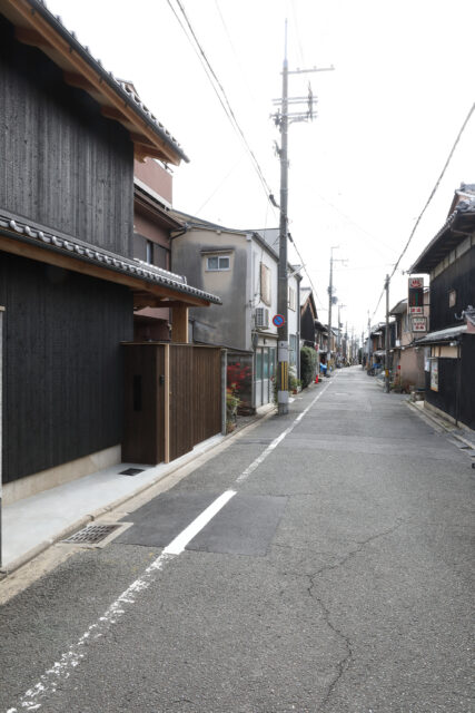 この作品の前から見た街並み。今は古い町家と現代の家が混在している。将来、この通りが現代的な町家が続く街並みとなることを目指している