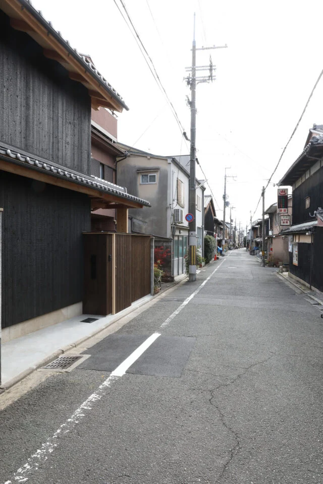 この作品の前から見た街並み。今は古い町家と現代の家が混在している。将来、この通りが現代的な町家が続く街並みとなることを目指している