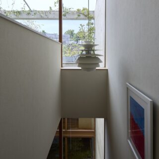 子世帯の階段からの眺め。正面に屋上庭園の緑、階下には中庭の緑が見え、階段も開放感がある