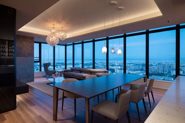 パノラマビューなリビング。建ち並ぶビルやマンションを見下ろし、遠くの山並みまで見渡せる圧倒的な開放感。夜になれば無数の灯りが瞬く幻想的な夜景が広がる。