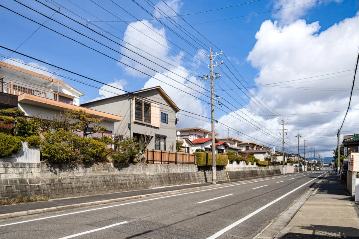 南側は道路から２mほど高い位置にあるY邸。車や向こう側の住宅からの視線に晒されない立地。大きな窓にもカーテン不用の開放的生活が送れる