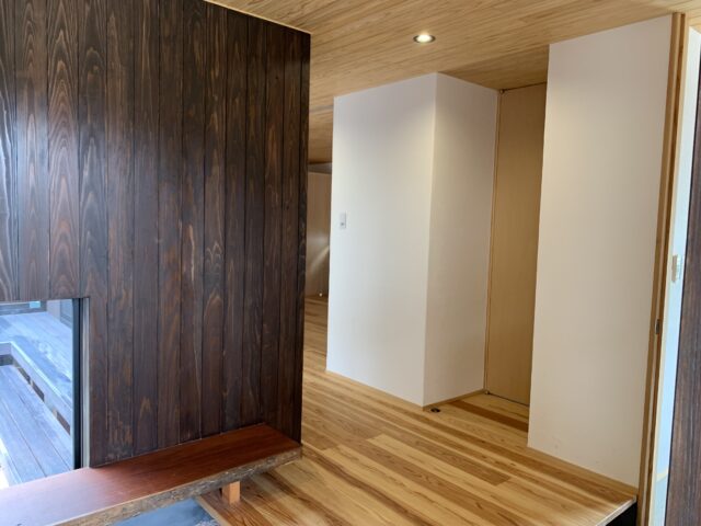 玄関ホール。中庭に面している壁はすべて杉板とし、アクセントに。その他の室内壁はしっくい。床は杉板のうずくりとした。自然素材を多用することで、メンテナンスが容易になり、家への愛着が湧く