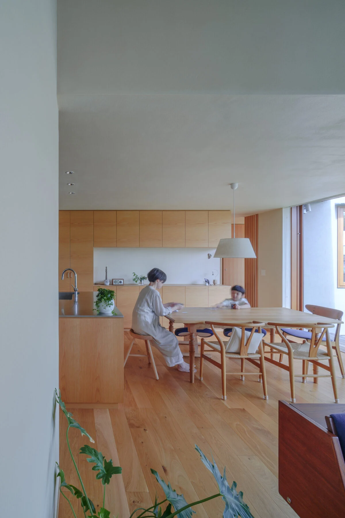 明るい光が差し込むダイニング。テーブル横は大容量の壁面収納。中には趣味で集めた作家モノの食器がずらり
