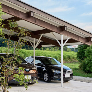 片流れ屋根のもっとも低い部分。屋根付き駐車場や作業などのフリースペースとして使われている。車を２台停められる、広大なエリアだ。長い張り出しなので、鉄製の支柱で強度を確保した