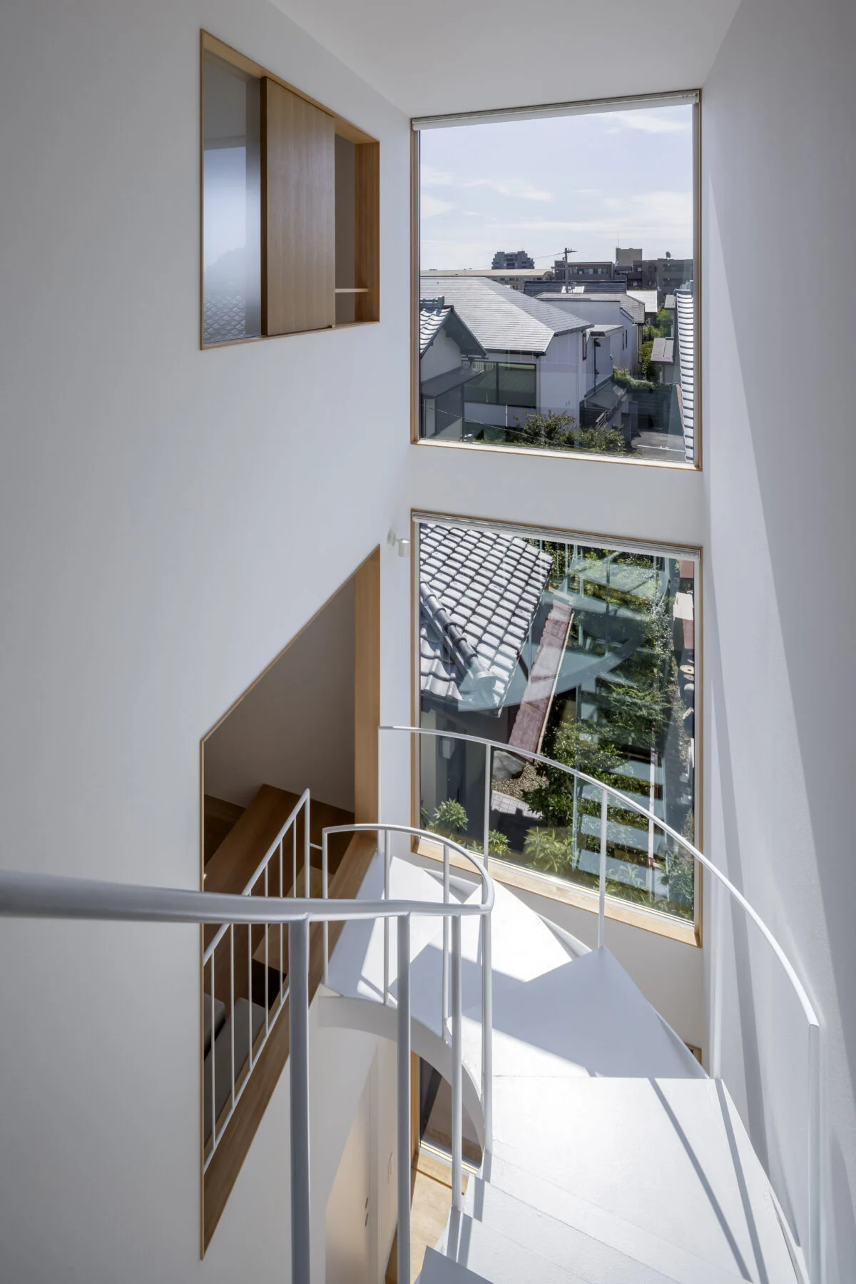 一段下がった敷地南側には斜線制限で今以上に高い建物が建たないことを見抜き、大胆に開口を設けて抜け感と採光を確保。真夏はロールスクリーンを下ろすこともできる