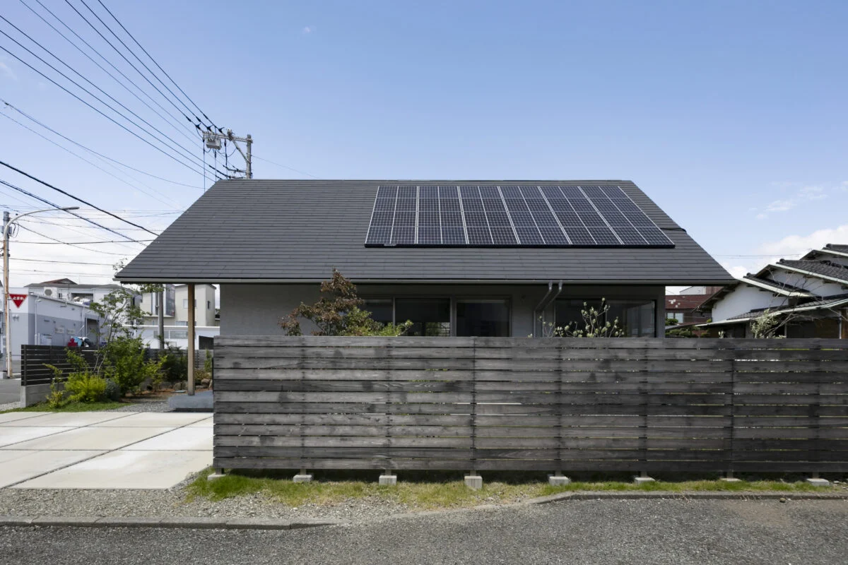集合住宅がある南側も大屋根と長い木塀でプライバシーを確保。木塀の内側は軒下テラス付きの庭があり、Aさんが望んでいた庭づくりを楽しめる