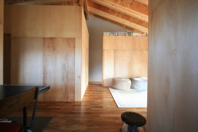 キッチンから家を見通す。縦も横も、壁から壁までを見通せる箇所が計画され、広さを存分に感じられる。左のテントは寝室。他は仕切りを省く、またはカーテンでの仕切りを選択したが、ここのみプライバシー確保のため扉をつけた