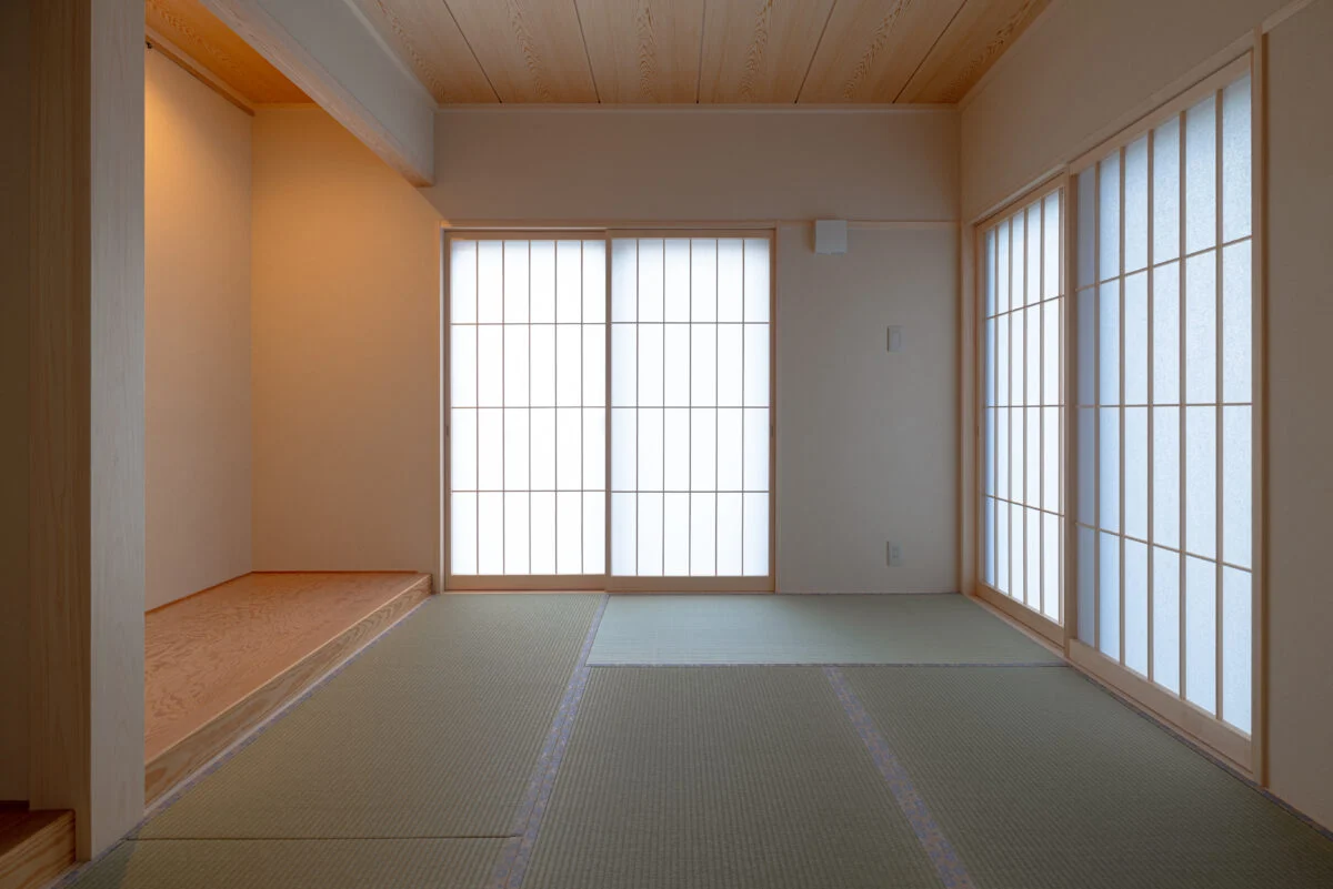 1階の客間兼和室。東面と北面に開口を設け、西日の影響を抑える計画としている。背面には親世帯の寝室へとつながる引き戸を配置