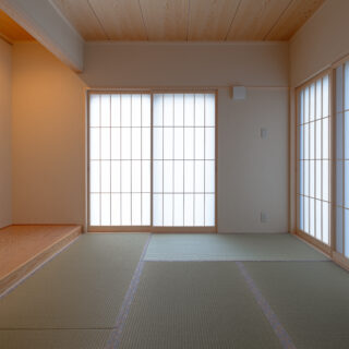 1階の客間兼和室。東面と北面に開口を設け、西日の影響を抑える計画としている。背面には親世帯の寝室へとつながる引き戸を配置