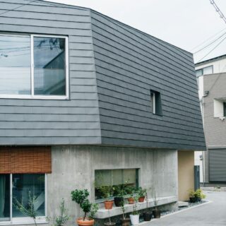 道路の幅に対して面が広いと「壁」の印象が強まってなじみにくくなるため、屋根や壁を多面的に分割。軒先に設けたベンチでは、ご近所のおばあちゃんが休憩する心温まる光景も
