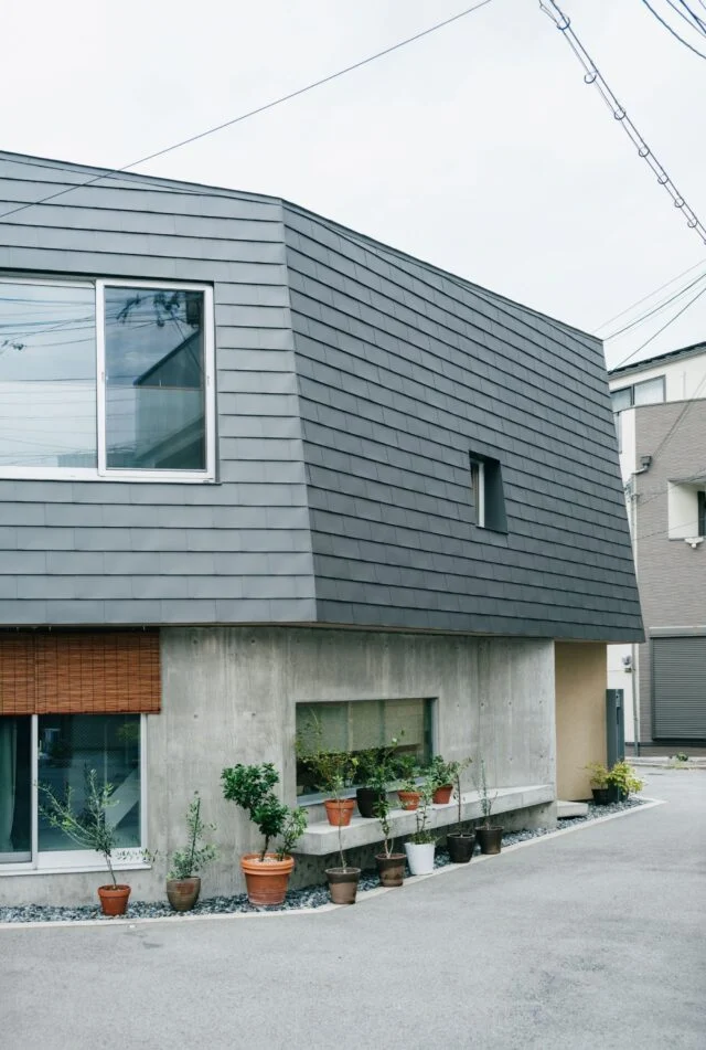 道路の幅に対して面が広いと「壁」の印象が強まってなじみにくくなるため、屋根や壁を多面的に分割。軒先に設けたベンチでは、ご近所のおばあちゃんが休憩する心温まる光景も
