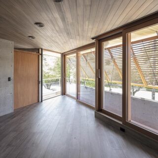 2階、広間からテラスの先端を見る。左手の引き戸は階段室。階段室からはそのままテラスに出ることも可能。天井やフローリングを鋭角に向けて割り付け、大きな開口とは異なる方向へ視線を誘う。コーナーに物を置くことを鋭角によって避け、空間の余白を維持する