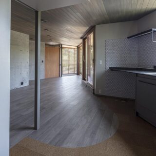 2階キッチンから広間、テラスまでを見通す。面積以上の奥行き感はこの家ならでは。柱の裏は客間として、柱を拠り所に引き戸とカーテンで仕切ることも可能。将来、寝室として２階だけでバリアフリーな生活を完結させることもできる